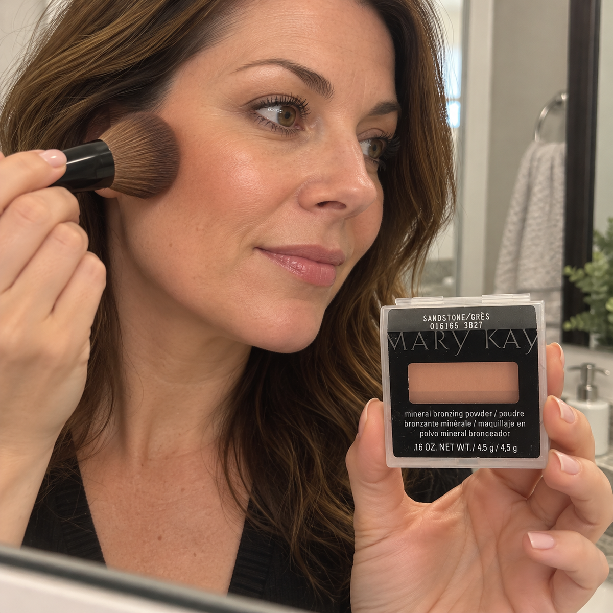Adult blending Mary Kay Sandstone bronzer onto her cheek