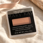 Mary Kay Sandstone mineral bronzing powder on cream linen with ribbon in the background