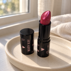 Mary Kay Empower Sparkle Cream Lipstick on a cream tray beside a window