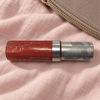Mary Kay Tropical Spice Lip Crème beside a taupe makeup pouch