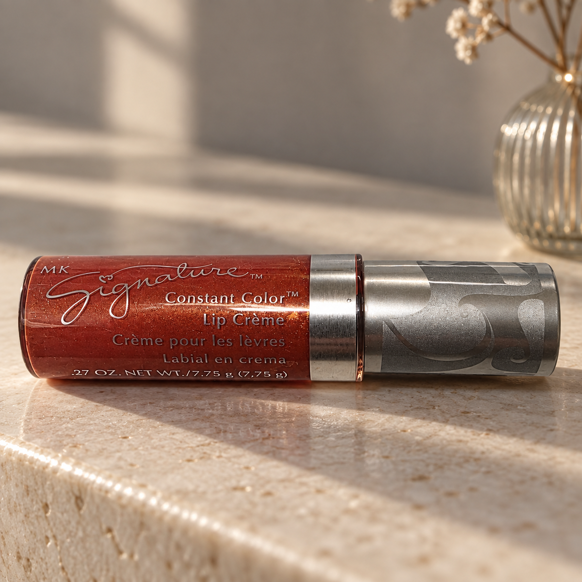Mary Kay Tropical Spice Lip Crème on a light stone console