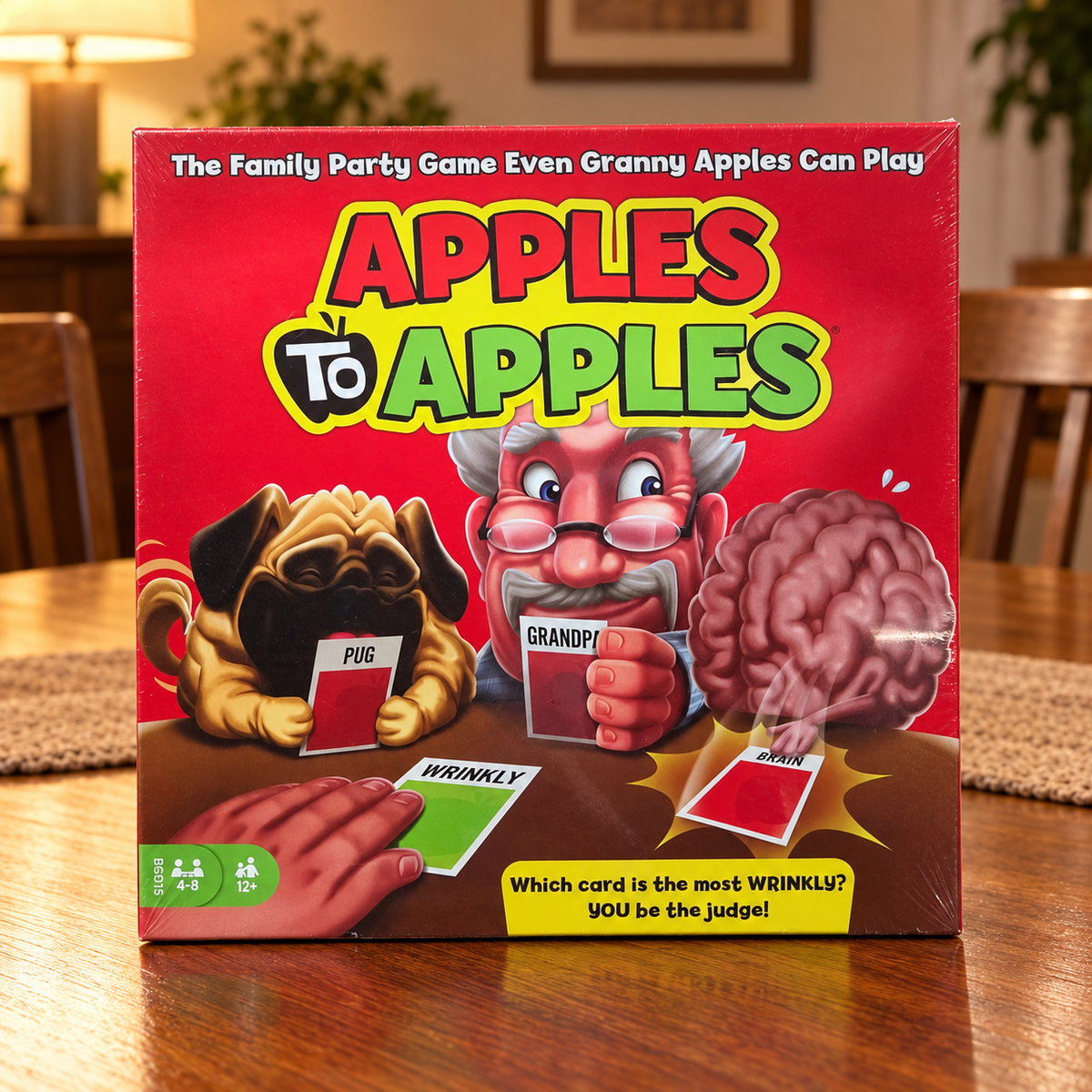 AI-generated lifestyle scene: closed Mattel Apples to Apples BGG15 game box on a dining table; furnishings not included.