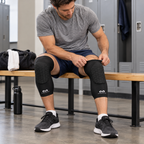 AI-generated illustration of a seated adult adjusting the upper cuff of one black McDavid 6446 HEX extended leg sleeve while wearing the pair.