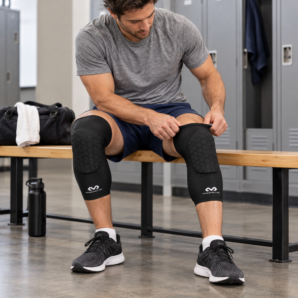 AI-generated illustration of a seated adult adjusting the upper cuff of one black McDavid 6446 HEX extended leg sleeve while wearing the pair.