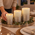 Arranging three silver-toned Mikasa LED candles on a dining-table tray