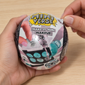 Illustrative adult hands peeling the wrapper from a closed Miniverse Make It Mini Makeup capsule.