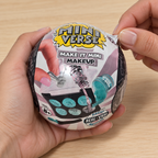 Illustrative adult hands peeling the wrapper from a closed Miniverse Make It Mini Makeup capsule.