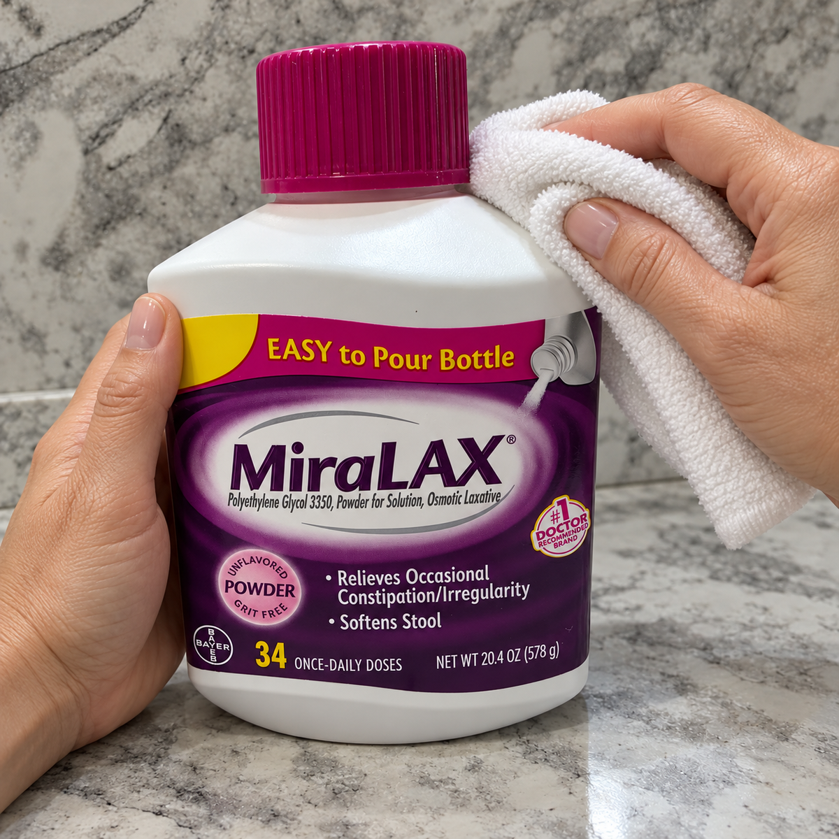 Wiping the outside of a capped MiraLAX powder bottle with a cloth