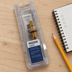 Packaged Moen 1225B replacement cartridge beside a notebook and pencil.