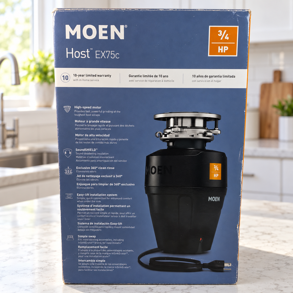 Moen Host EX75c 3/4 HP retail carton in a bright kitchen countertop setting; package illustration shows the black corded disposal.