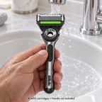 Adult rinsing a GilletteLabs cartridge on a compatible Exfoliating Bar handle; handle not included