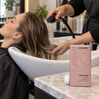 Stylist rinsing damp hair lengths beside KEVIN.MURPHY ANGEL.RINSE 250 mL conditioner