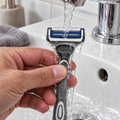 SkinGuard replacement cartridge being rinsed on a compatible handle; handle is not included with the refills