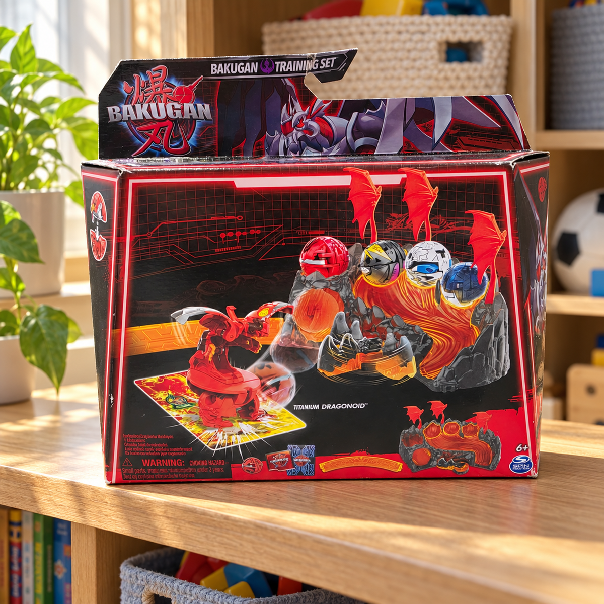 AI-generated context: pictured Bakugan Titanium Dragonoid Training Set retail carton with creases and edge wear on a wood playroom shelf with baskets in the background; room props not included, extra figures printed on carton are not additional included toys.