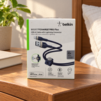 AI-generated lifestyle illustration of the boxed Belkin Pro Flex blue 2 m USB-A to Lightning cable in a bedside room; background props not included