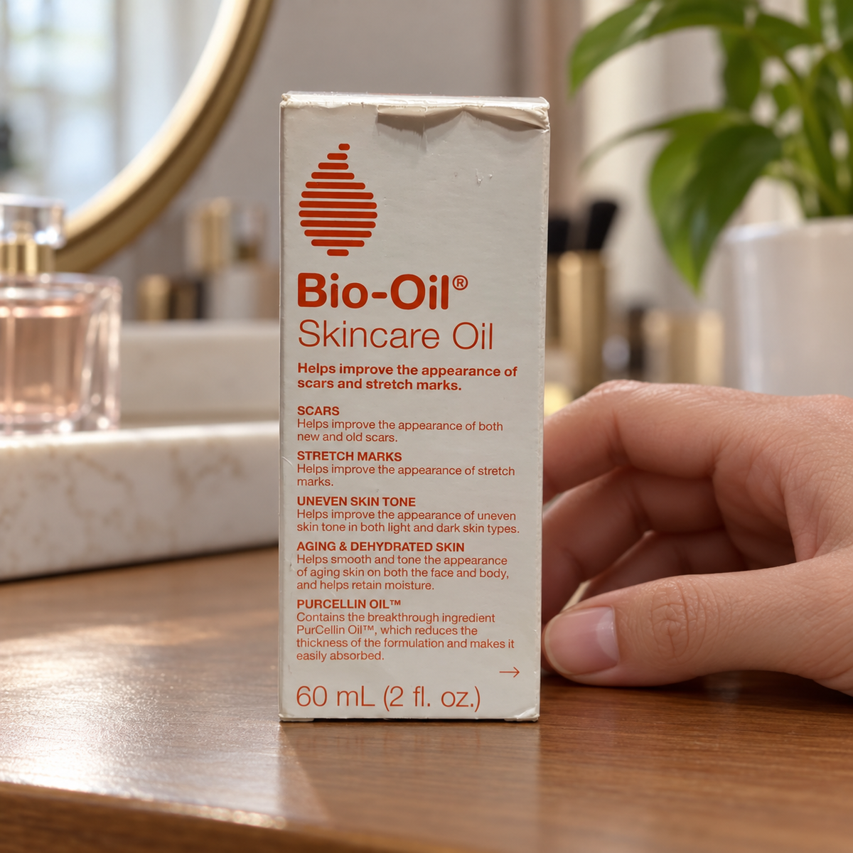 AI-generated lifestyle illustration of the same Bio-Oil 60 mL retail carton with top creasing beside a hand on a dressing table; props excluded.