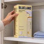 Blueland Multi-Surface Cleaner starter-set carton being placed on a dry utility cupboard shelf
