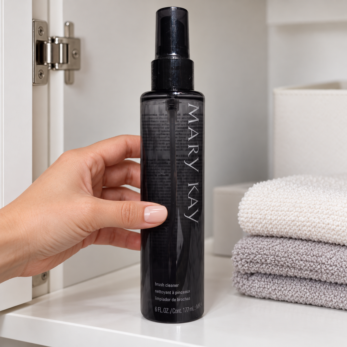 Placing a capped Mary Kay Brush Cleaner bottle upright in a clean cabinet.