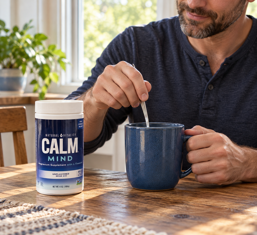 Stirring a drink in a ceramic mug beside a CALM Mind 6 oz tub.