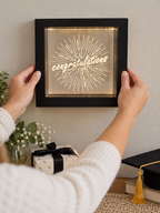 Positioning the black Congratulations light box on a wall above a graduation table