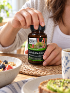 Opening a Gaia Herbs Quick Defense 40-capsule bottle at breakfast.