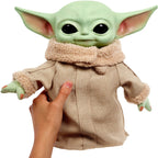 A hand squeezing Squeeze & Blink Grogu's belly with one arm raised.
