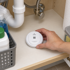 Placing a Kidde water leak detector flat on the cabinet floor beneath a sink