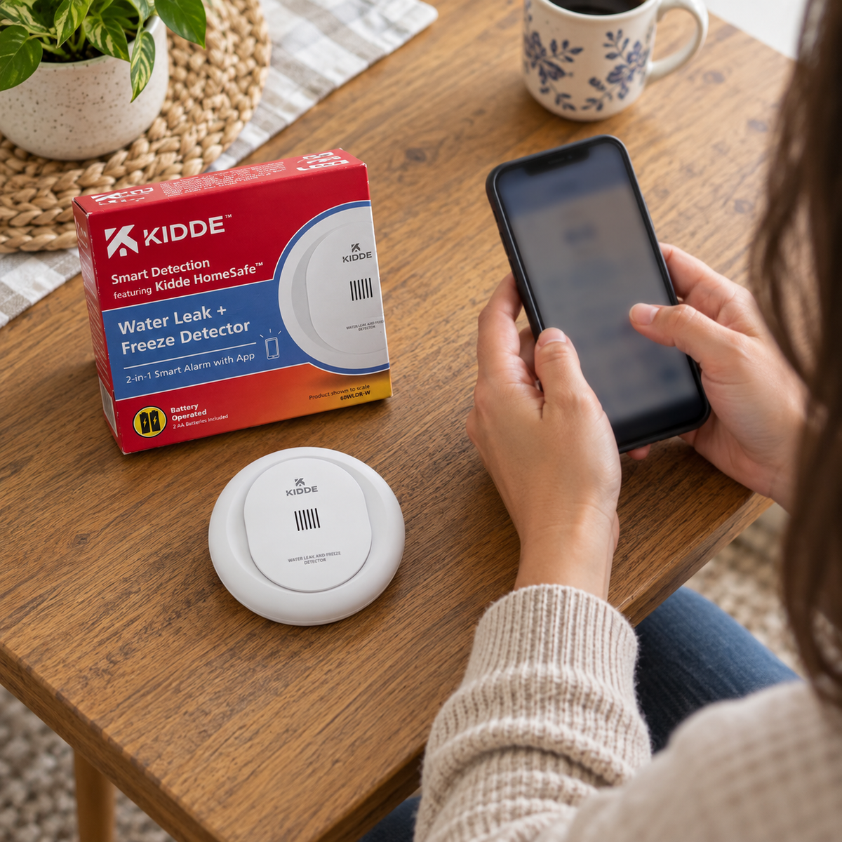 Setting up a Kidde leak detector with a smartphone beside its box