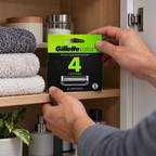Putting one four-count GilletteLabs refill carton into a bathroom cabinet