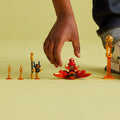 Child preparing LEGO NINJAGO Kai's Dragon Power Spinjitzu Flip 71777 with its spinner, droid and flame obstacles.