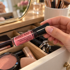 Choosing Pink Luster lip gloss from a vanity drawer