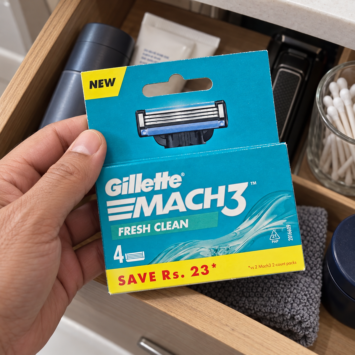 Selecting a Mach3 Fresh Clean four-count refill pack from a bathroom drawer