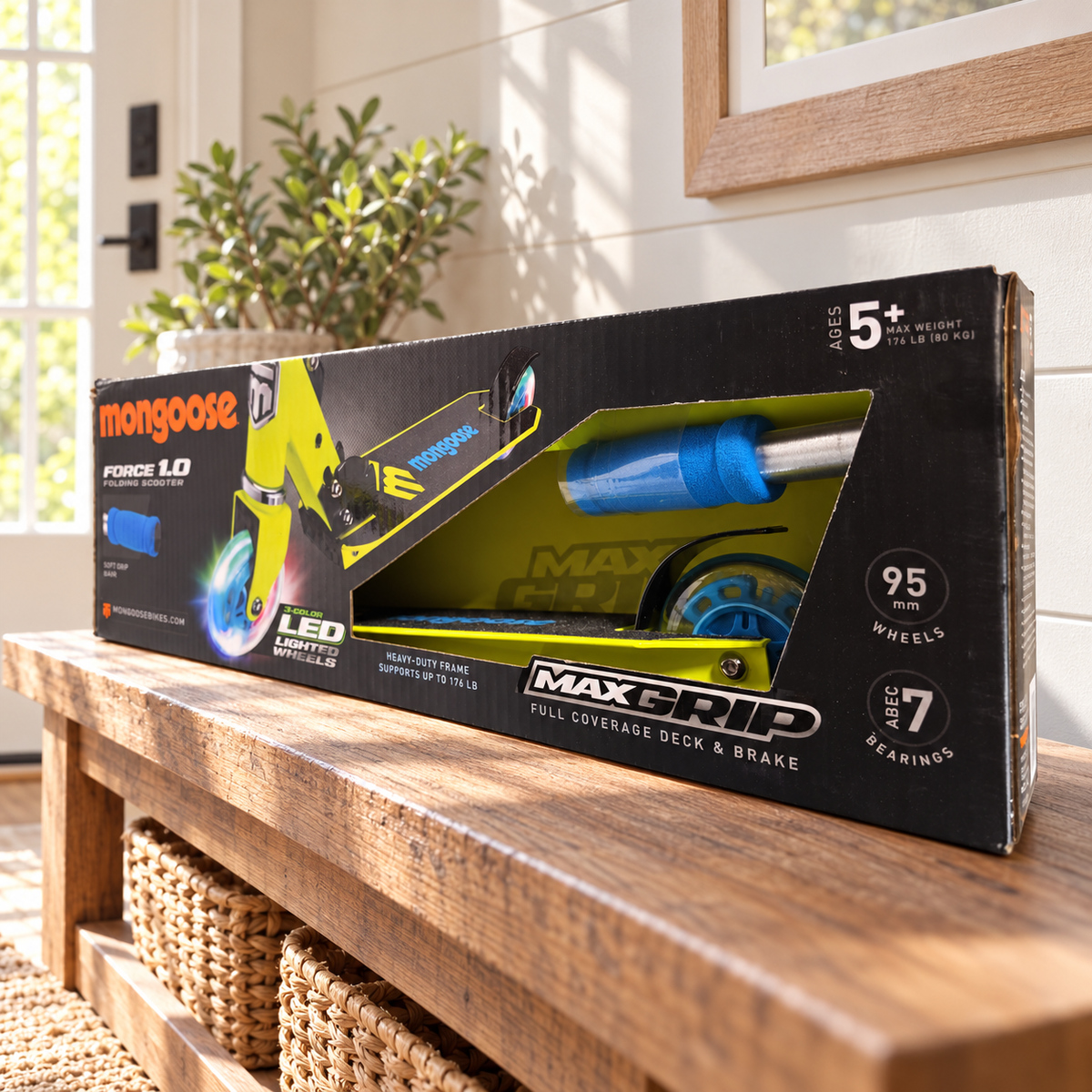 Mongoose Force 1.0 LED wheel scooter in original lime and blue retail packaging, styled entryway setting