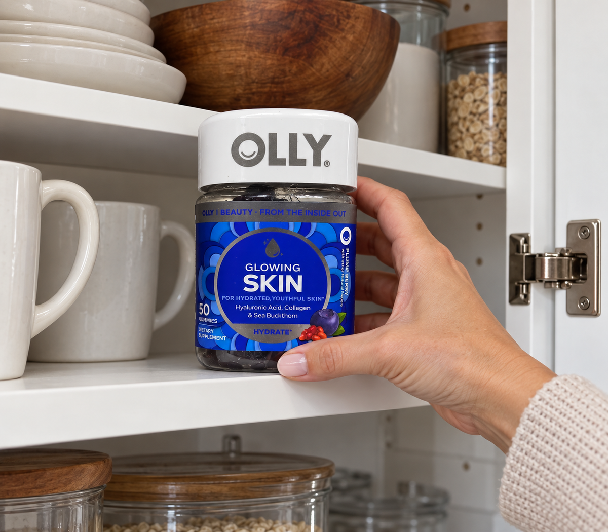 Putting a closed OLLY Glowing Skin jar on a kitchen cupboard shelf.