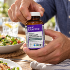 Hands preparing to open a New Chapter multivitamin bottle beside a meal