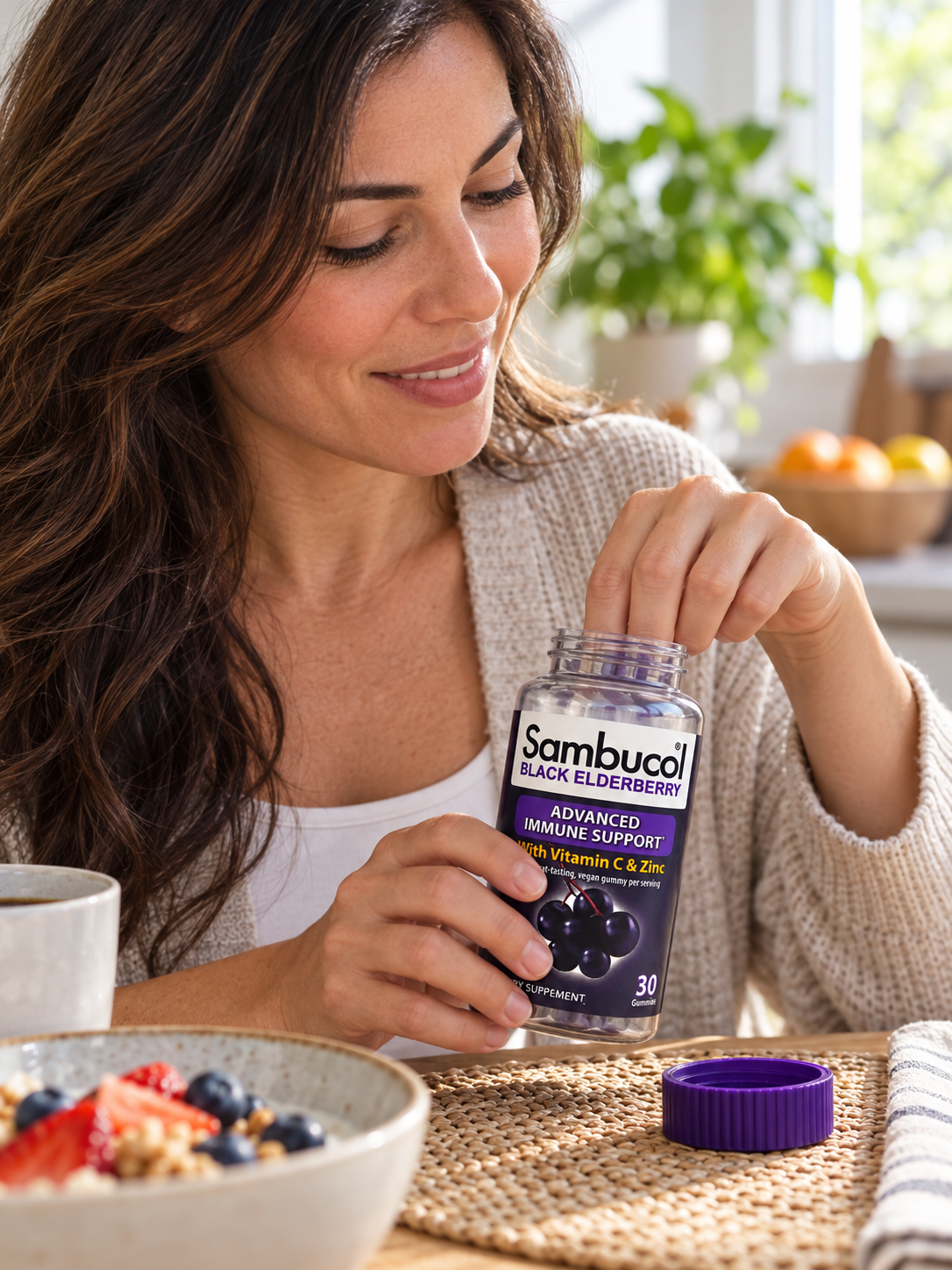 Reaching into a Sambucol Black Elderberry gummy bottle during breakfast.