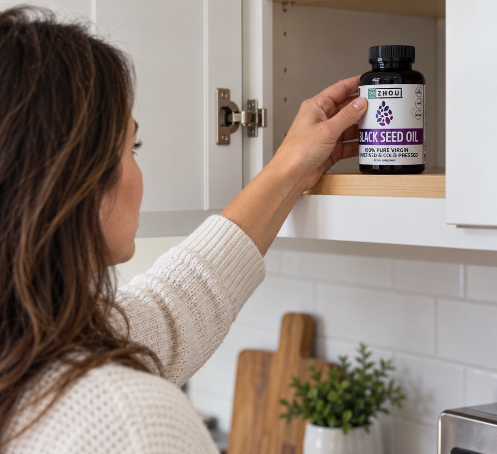 Placing a closed Zhou Black Seed Oil bottle on a kitchen shelf.