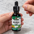 AI-generated illustration of adult hands peeling the clear outer neck band from Nature's Answer Mullein Leaf Alcohol-Free Extract, 1 fl oz, with the dropper cap closed.