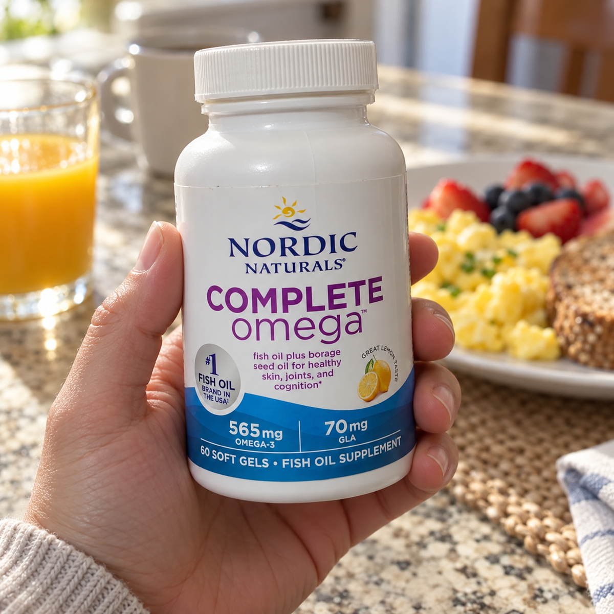An adult holding a Nordic Naturals Complete Omega 60-soft-gel bottle at a breakfast table