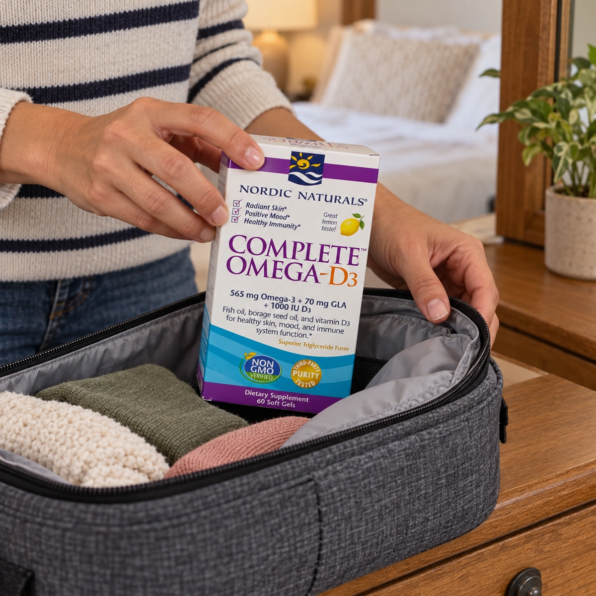 An adult packing the Nordic Naturals Complete Omega-D3 60-soft-gel box in a fabric travel organizer