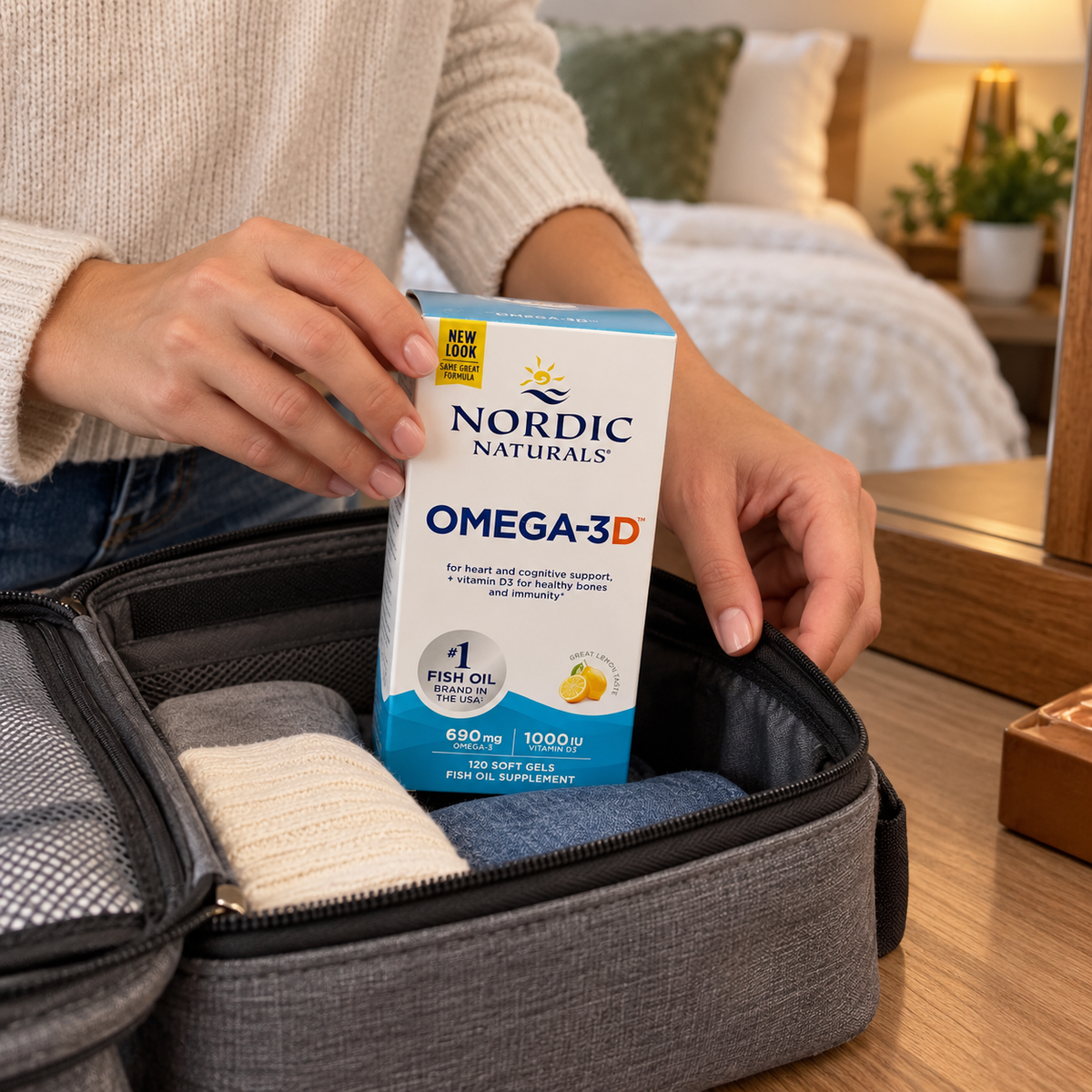 An adult packing the Nordic Naturals Omega-3D 120-soft-gel box in a fabric travel organizer