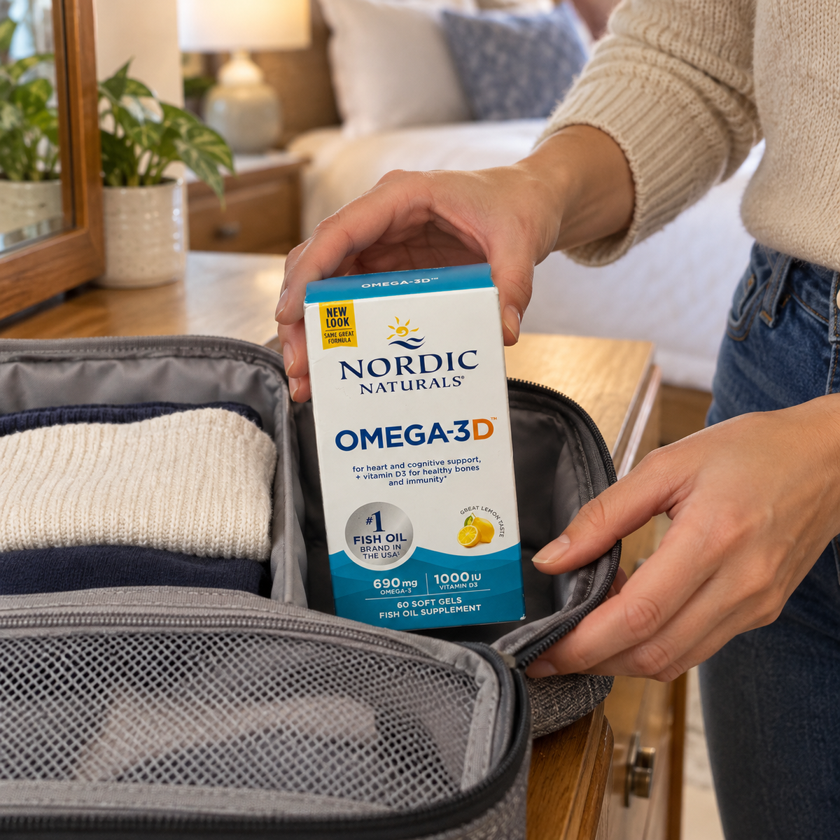 An adult packing the Nordic Naturals Omega-3D 60-soft-gel box in a fabric travel organizer