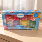 AI-generated lifestyle scene of the NORO eight-pot lip balm set in its retail box; props not included.