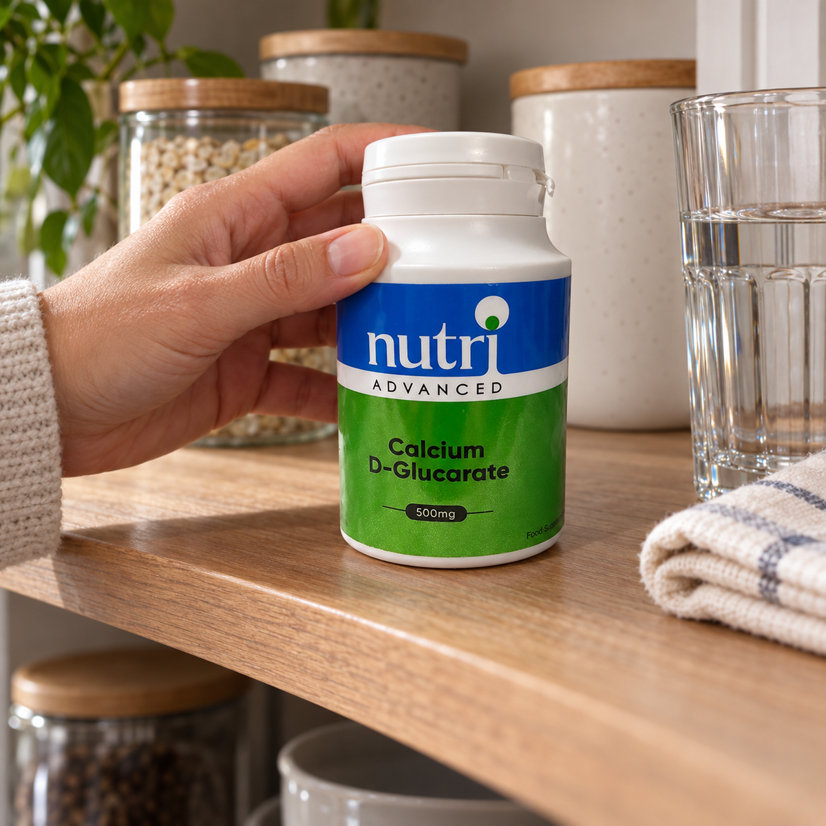Adult putting a Nutri Advanced Calcium D-Glucarate bottle on a dry shelf