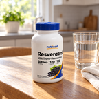 Nutricost Resveratrol 500 mg 120-capsule bottle on an oak table beside water and linen.