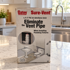 AI-styled illustrative kitchen scene with Oatey Sure-Vent 39016 retail box; contents not shown