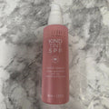 Pacifica Kind Tint SPF 30 tinted serum, 1.7 fl oz pink pump bottle on a marble background.