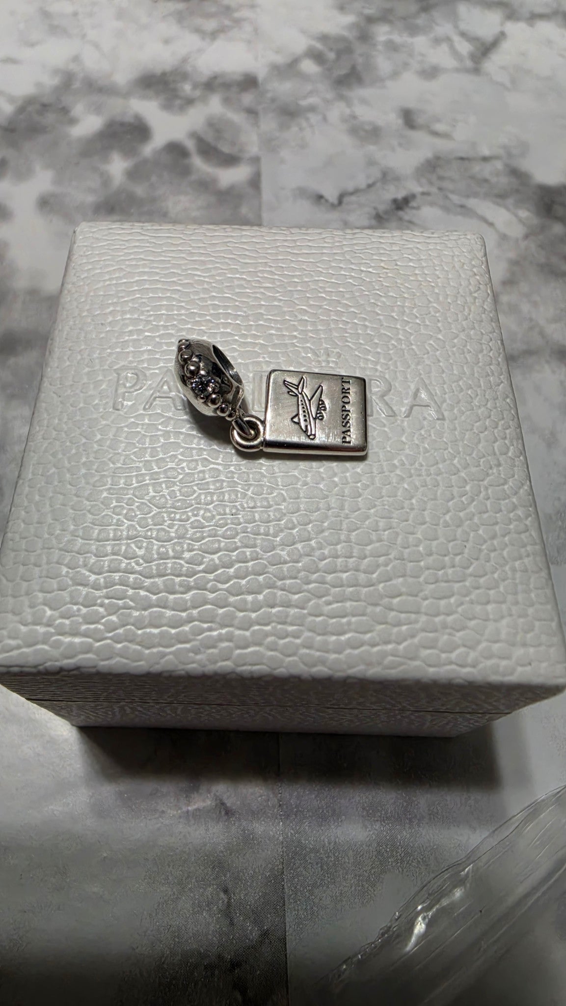 Actual Pandora Passport Travel Dangle Charm on its white box