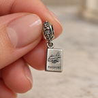 Close view of the passport dangle charm held by its decorative bail