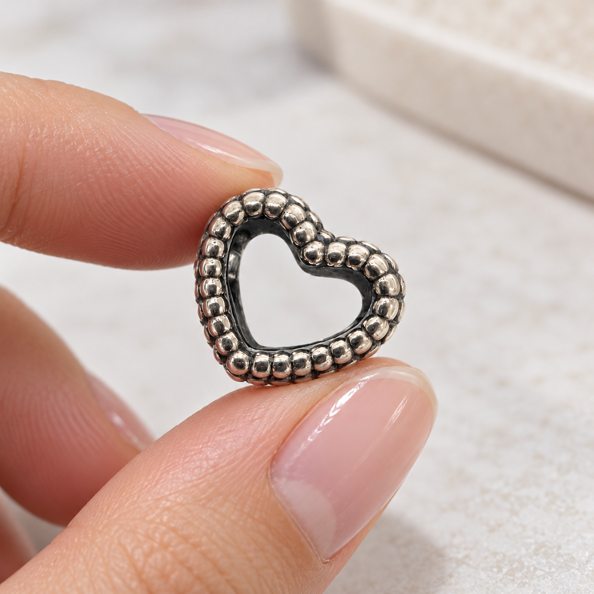 Pandora open heart charm held gently between fingertips